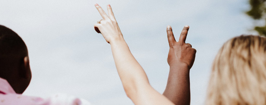 Two arms raised with peace fingers